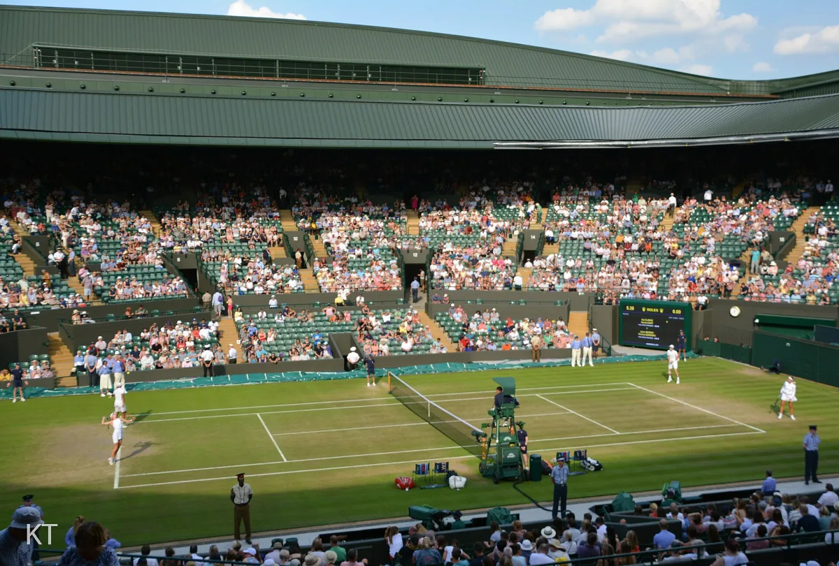 Four tennis players competing in a mixed doubles match on grass